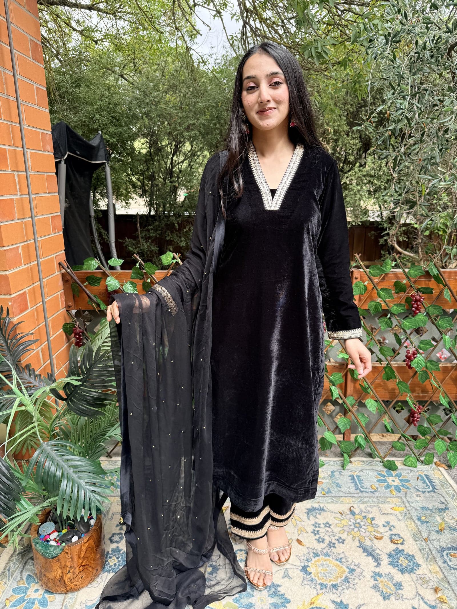 Black velvet kurta-pant set with gold lace detailing — editorial reference