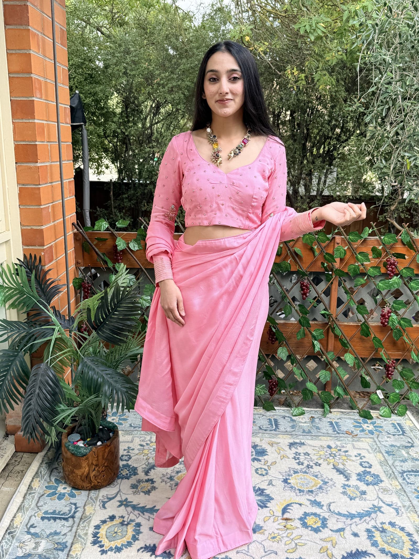 Blush pink pre-draped Banarasi saree, photographed flat on warm parchment ground
